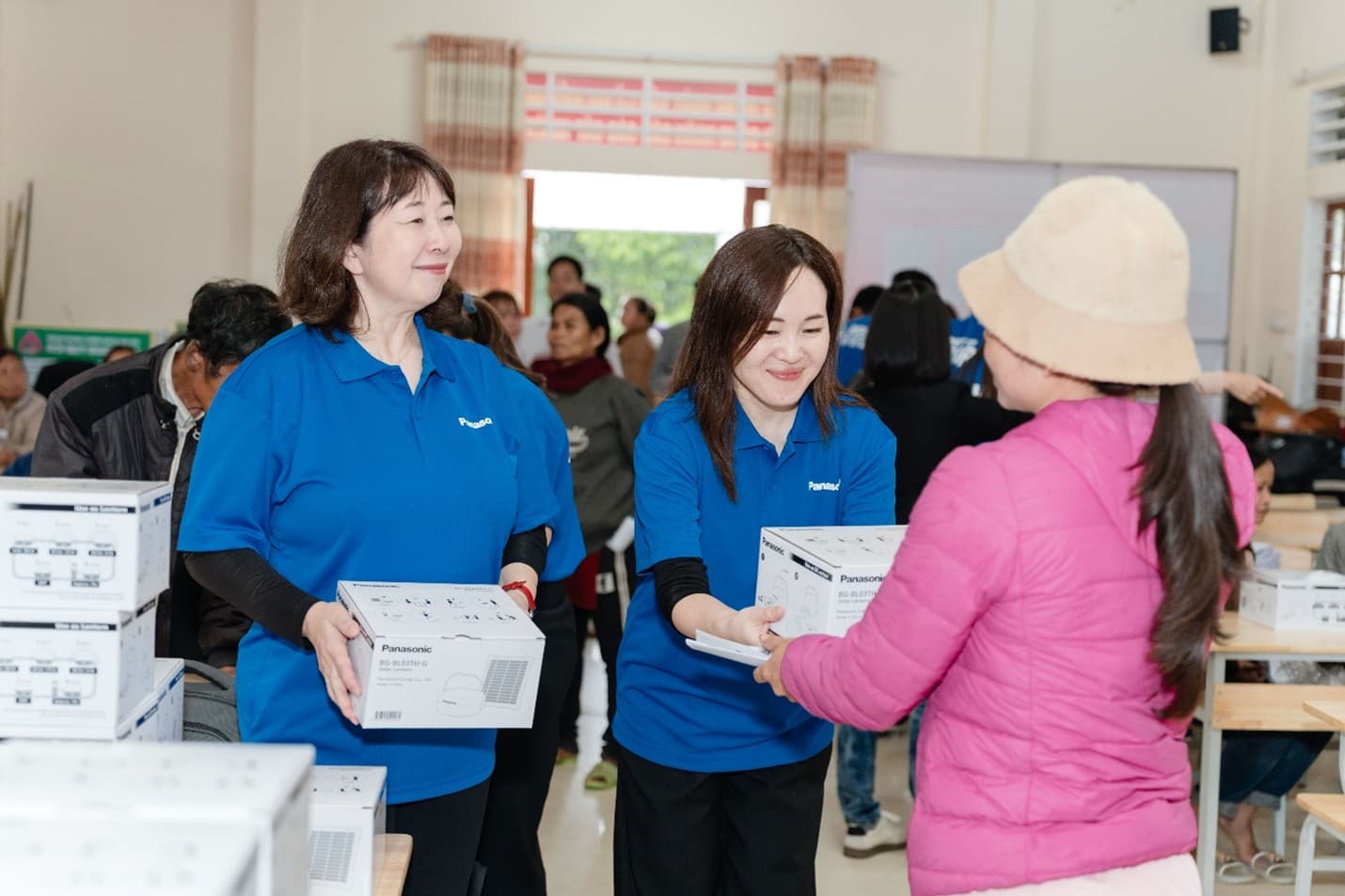 Các cán bộ Tập đoàn Panasonic Holdings trực tiếp trao tặng đèn cho người dân